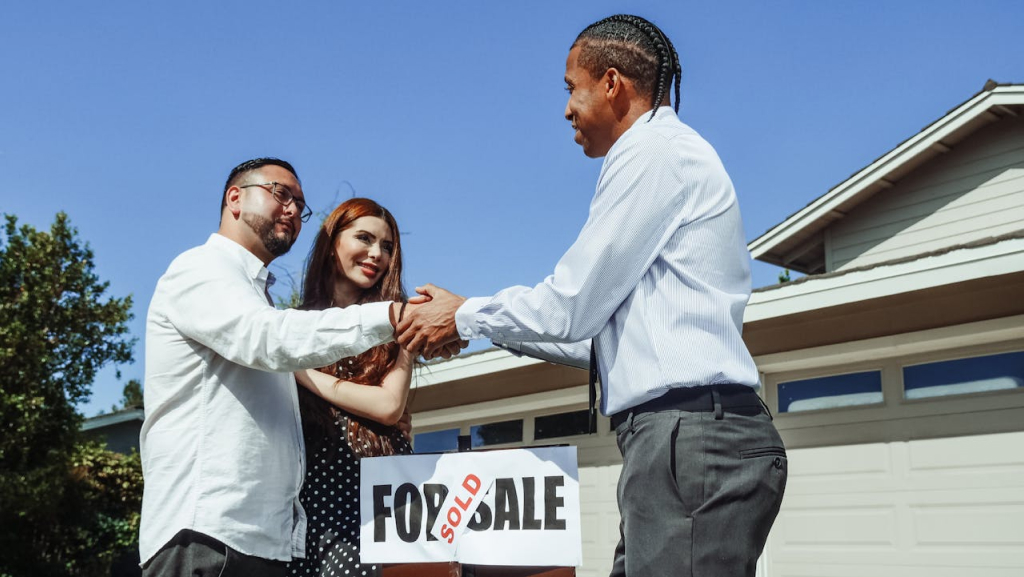a buyer shaking hands with realtor after buying a house, property taxes in tracy ca