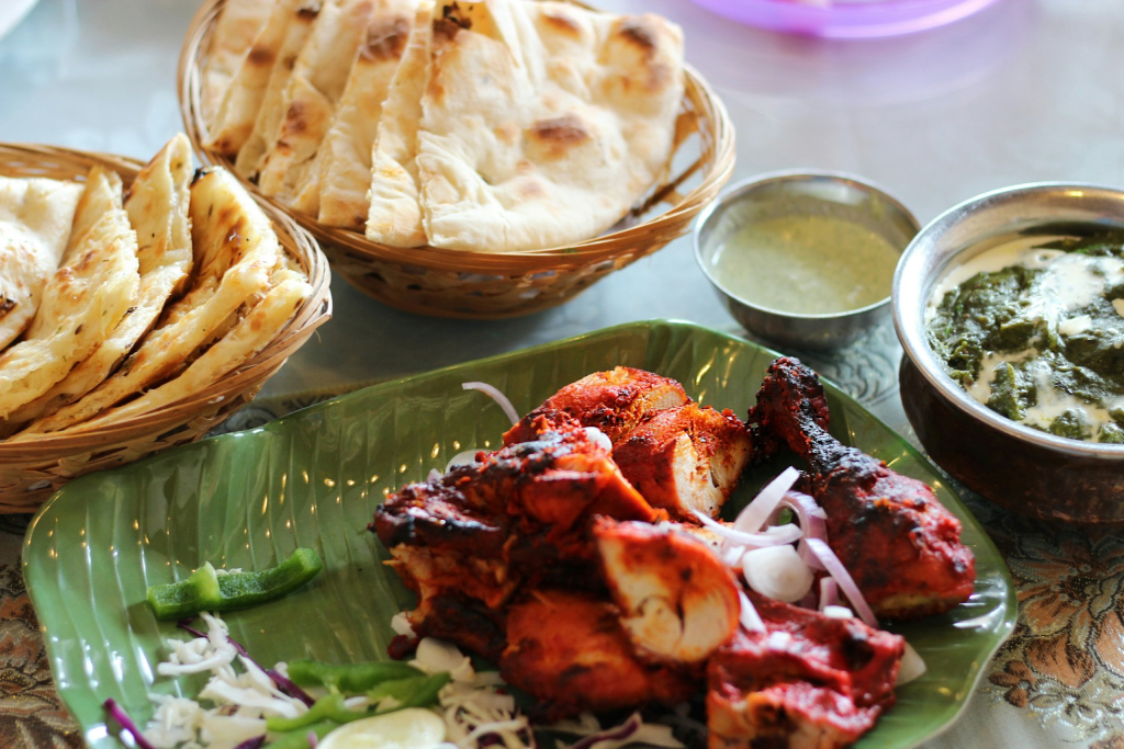 a plate of chicken, naan bread and spicy sauce in the best restaurants in mountain house